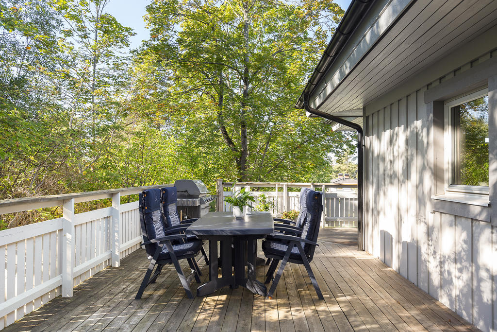 Gaveln av huset, med den stora terrassen  som nås från kök
