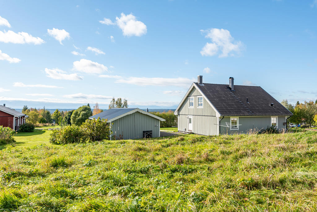 Vy mot mot huset med fjällvärlden i horisonten. 