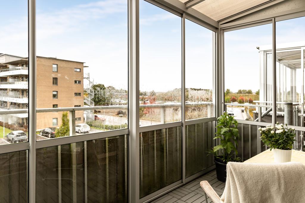 Inglasat balkong med plats för utemöbler.
