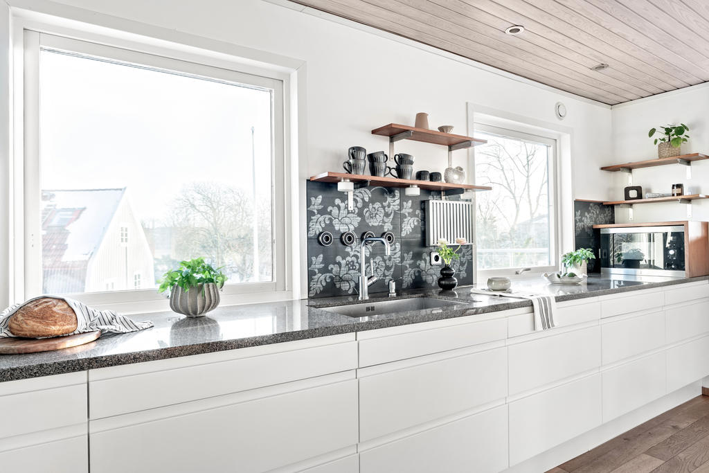 Ovan köksskåpen ligger en snygg bänkskiva i Bohusgranit.