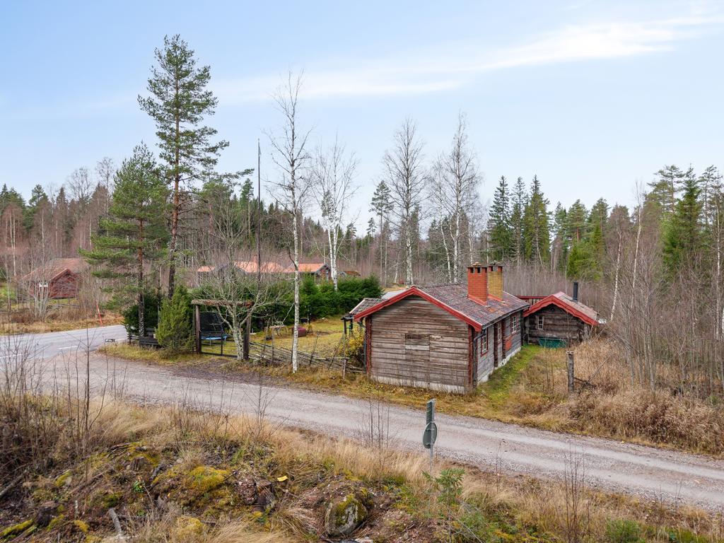 Charmig gårdsmiljö omgiven av skog och natur.