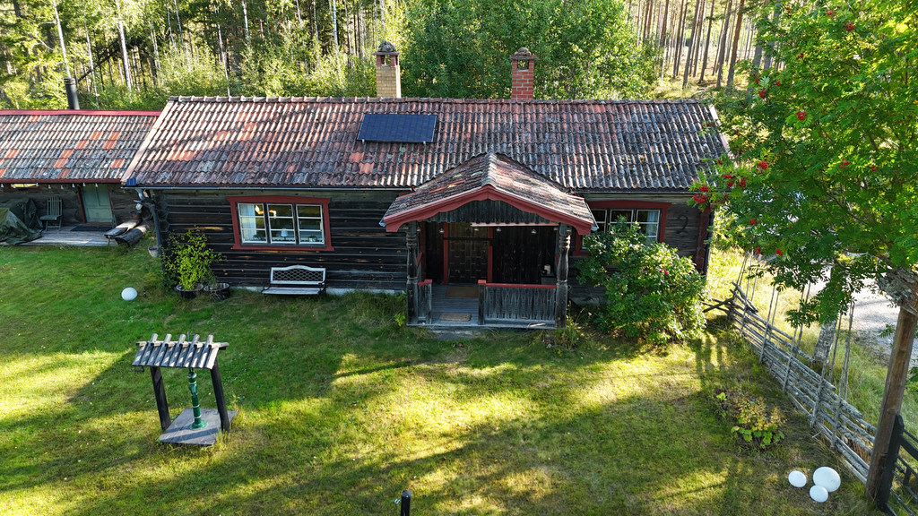 Charmig gårdsmiljö omgiven av skog och natur.