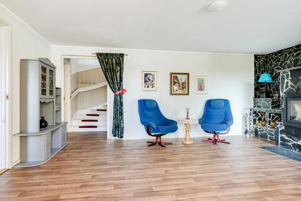 Hemtrevligt vardagsrum med rejäl kamin och utgång till balkong-nedre plan.