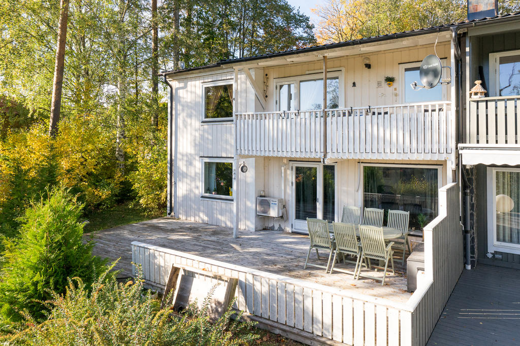 Trivsam altan med plats för utemöbler samt balkong på övre plan. 