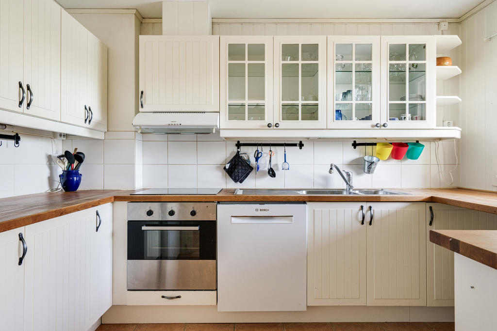 Funktionellt kök med vit inredning.