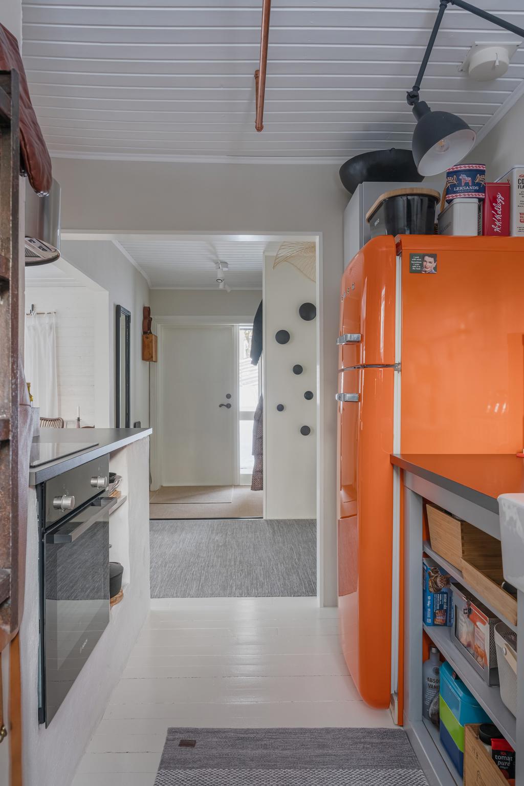 Vy från köket mot entrén, med öppen planlösning och fint ljusinsläpp.