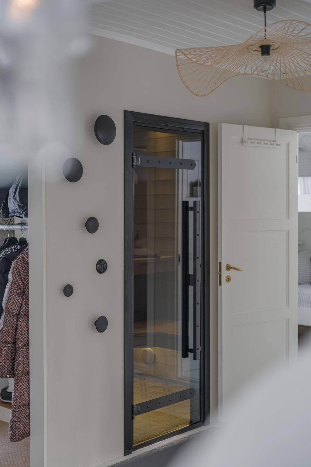 Stilren inomhusbastu med glasad dörr, invändig belysning och modern design.