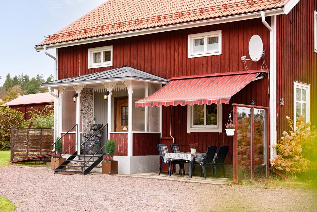 Välkommen hit! Ett rött hus med klassisk charm och inbjudande uteplats.
