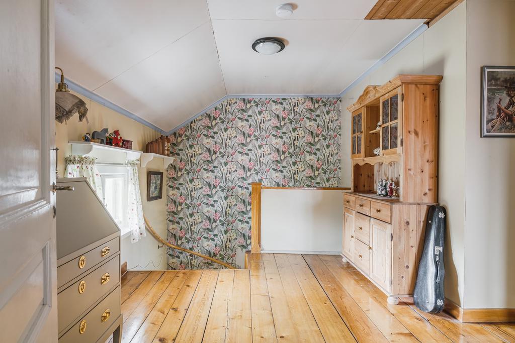 Hall på övervåningen med trägolv och plats för förvaring.