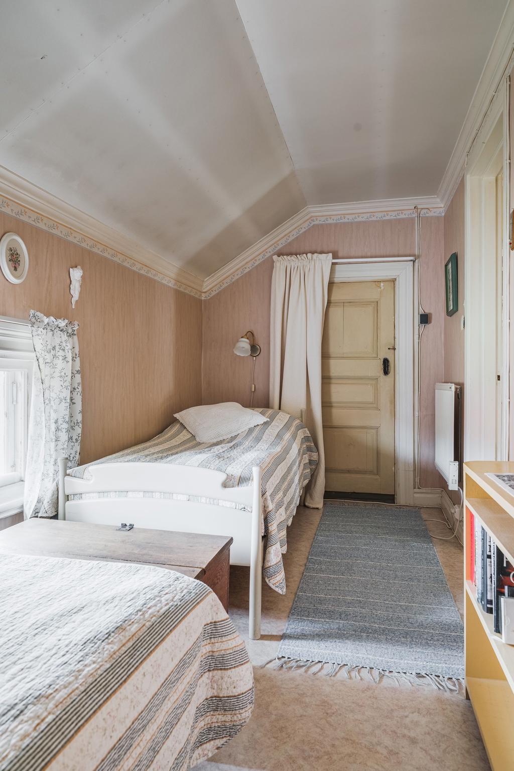 Mysigt sovrum med snedtak och fönster som ger ett fint ljus.