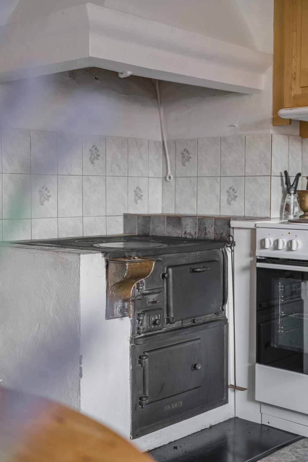 I köket finns en vacker vedspis i gjutjärn som både bidrar med värme och ger rummet en charmig, lantlig karaktär.