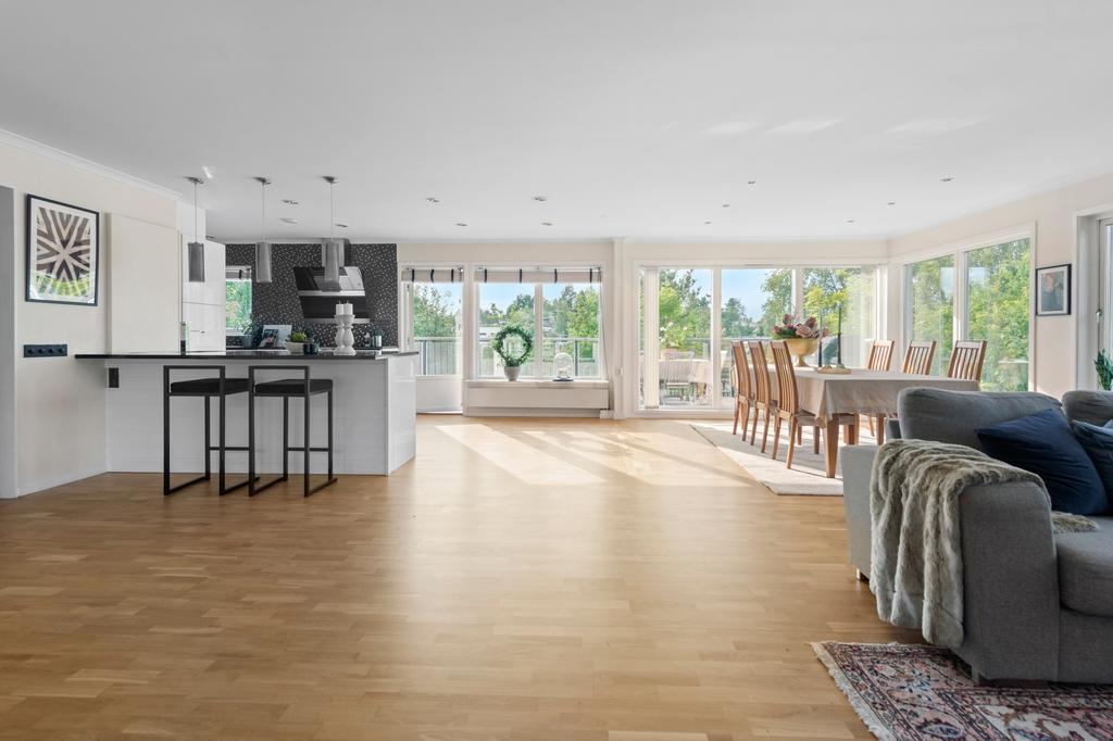 Generöst och socialt vardagsrum och kök med direktaccess till möblerbar längsgående terrass
