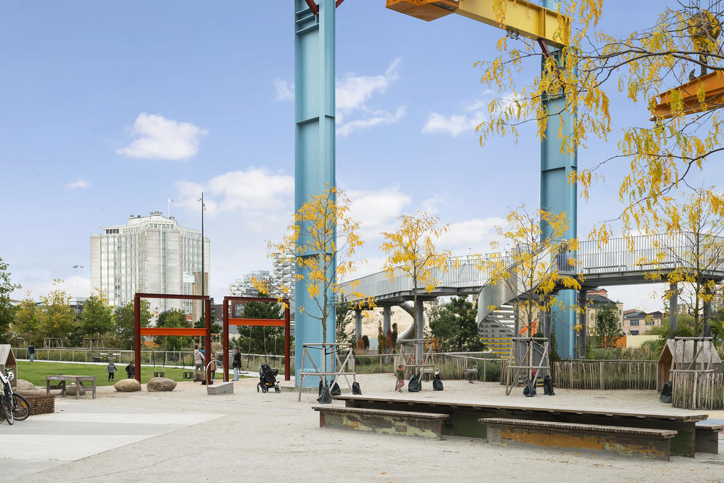 Här går en lekfull stålkonstruktion som fungerar som gångbro genom parken.