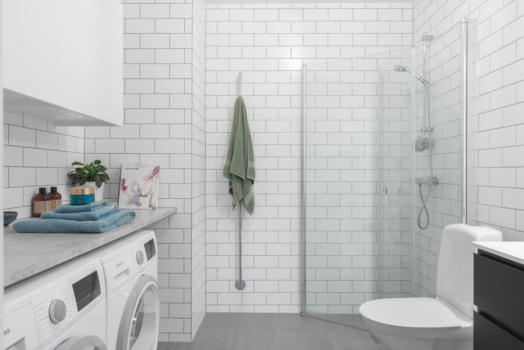 Helkaklat badrum med egen tvättavdelning.