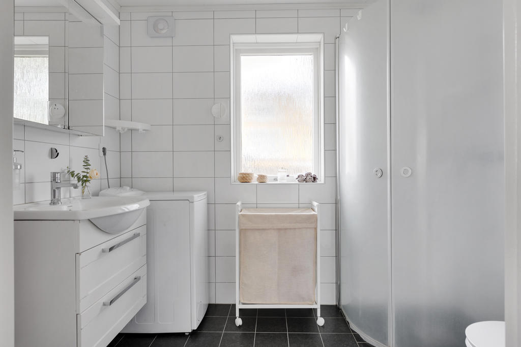 Helkaklat badrum med dusch och toppmatad tvättmaskin