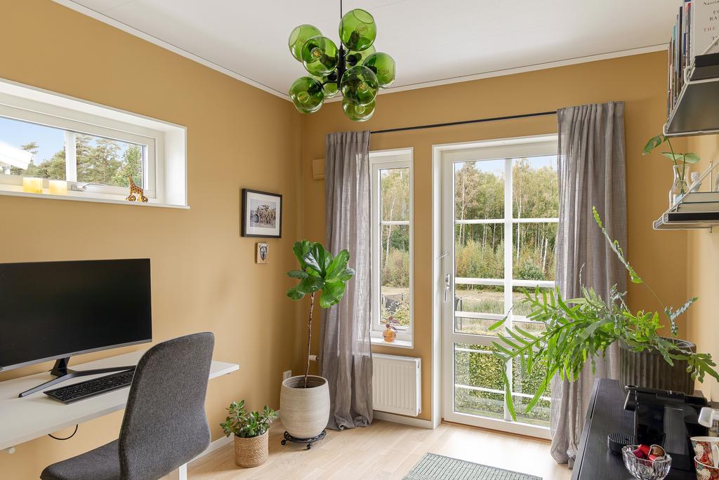 Ett av de tre sovrummen på ovanvåningen är idag inrett som ett stilfullt kontor. Även här har ni fina vyer mot grönområdet 