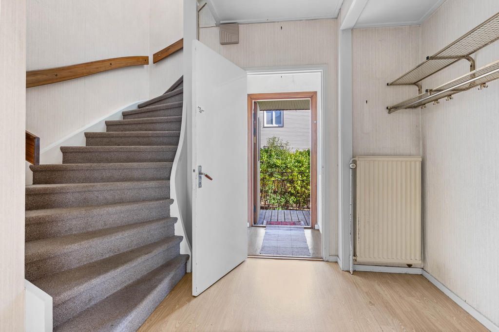 Hall med klädavhängning och trapp till ÖV