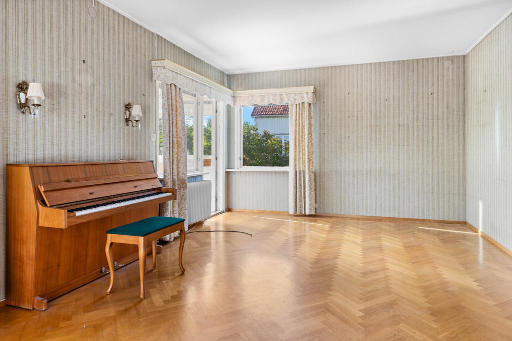 Vardagsrum med fiskbensparkett och utgång till inglasade altanen