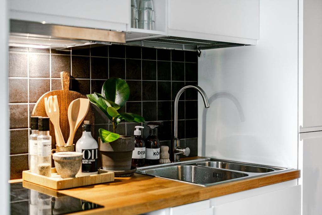 Fräscht kök med liten spishäll, fläkt samt kyl/frys.