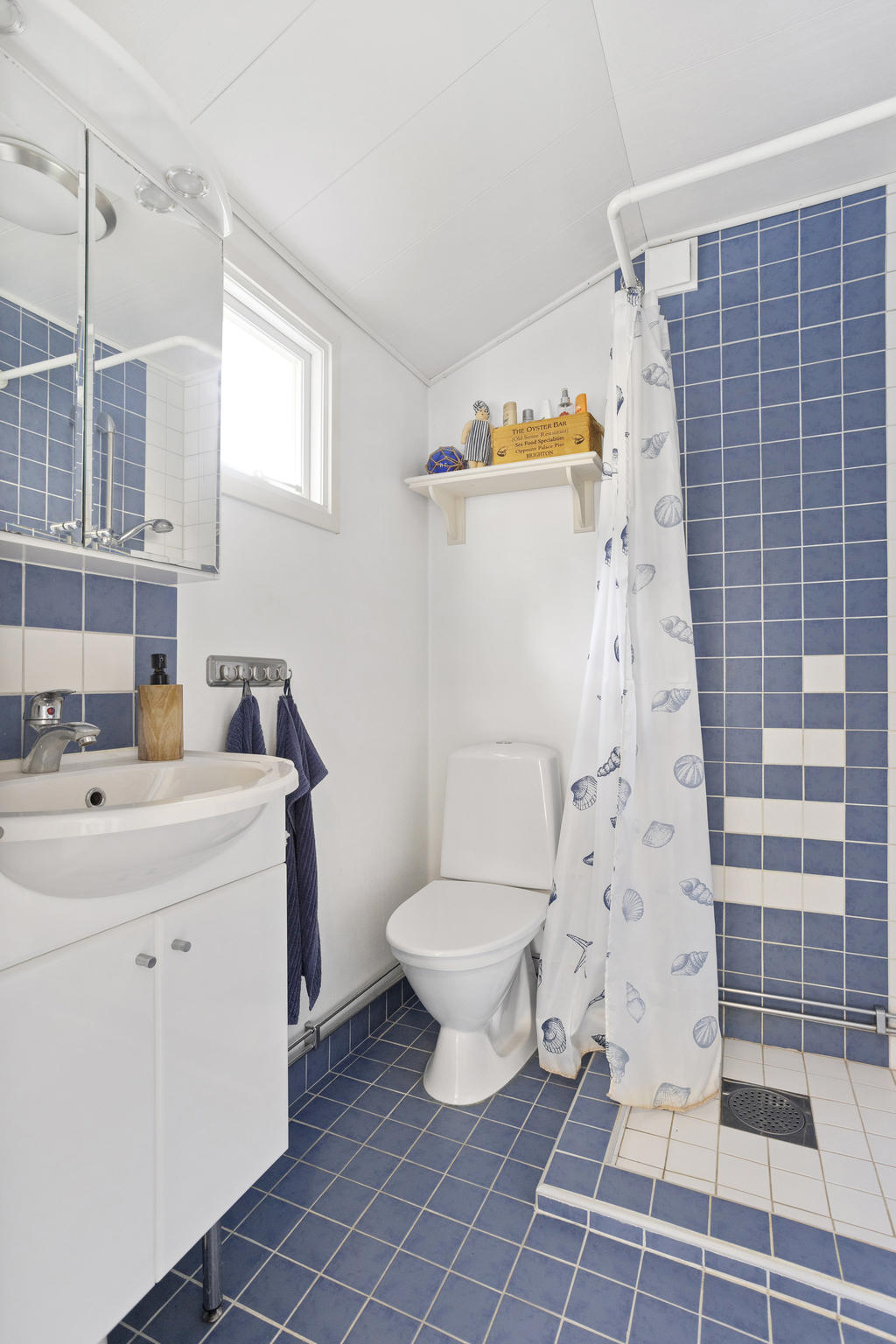 Helkaklat badrum med dusch, toalett och handfat. Utrustad med elektrisk golvvärme