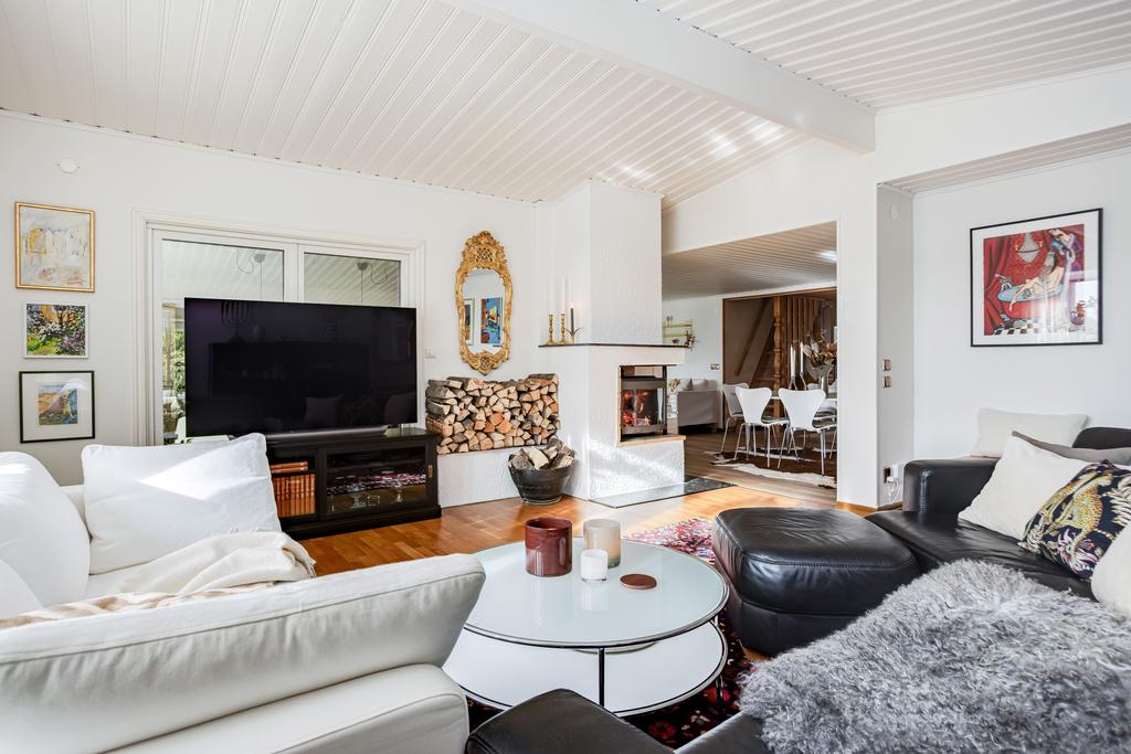 Vardagsrummet är särskilt tilltalande med sin högre takhöjd, vackert burspråk med stort fönsterparti samt en stämningsfull kamin som ger både värme och karaktär.