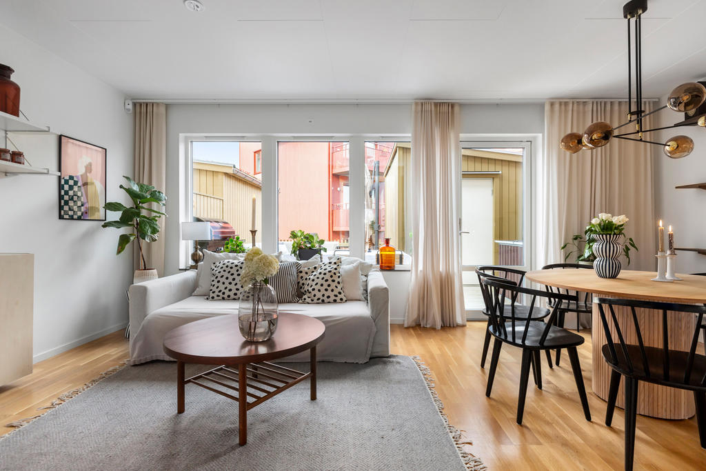Vardagsrum med utgång till altan och bostadens förråd 