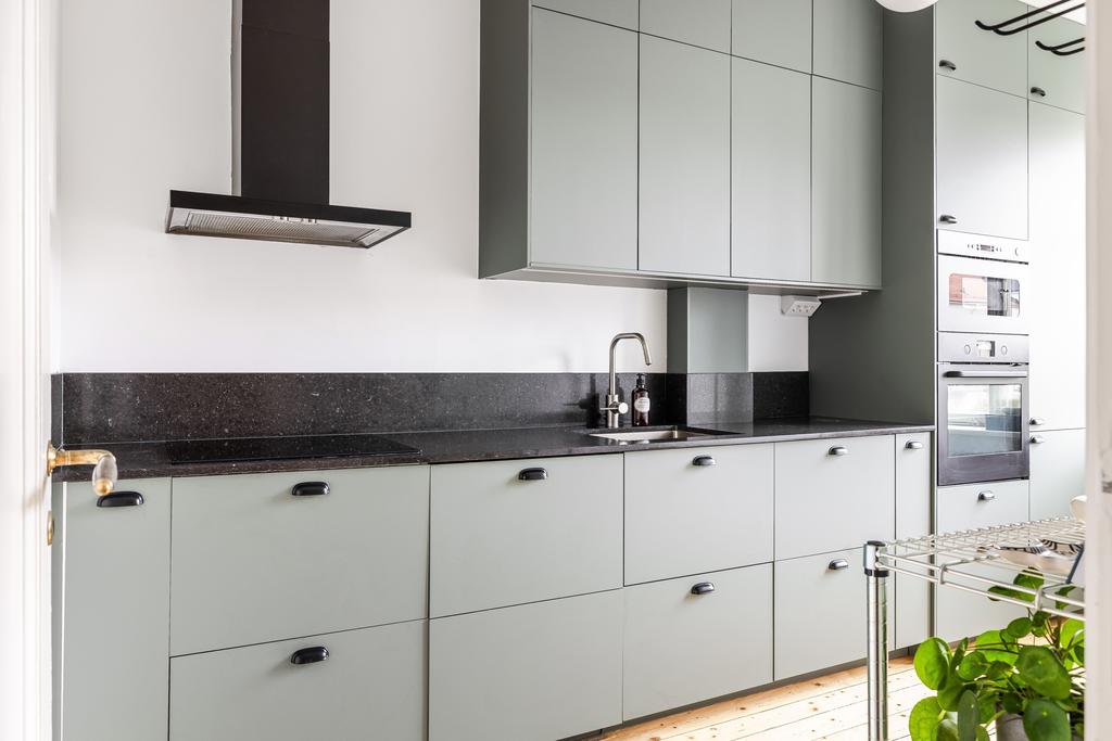 Stilrent kök med integrerad diskmaskin samt kyl och frys som smälter in i inredningen