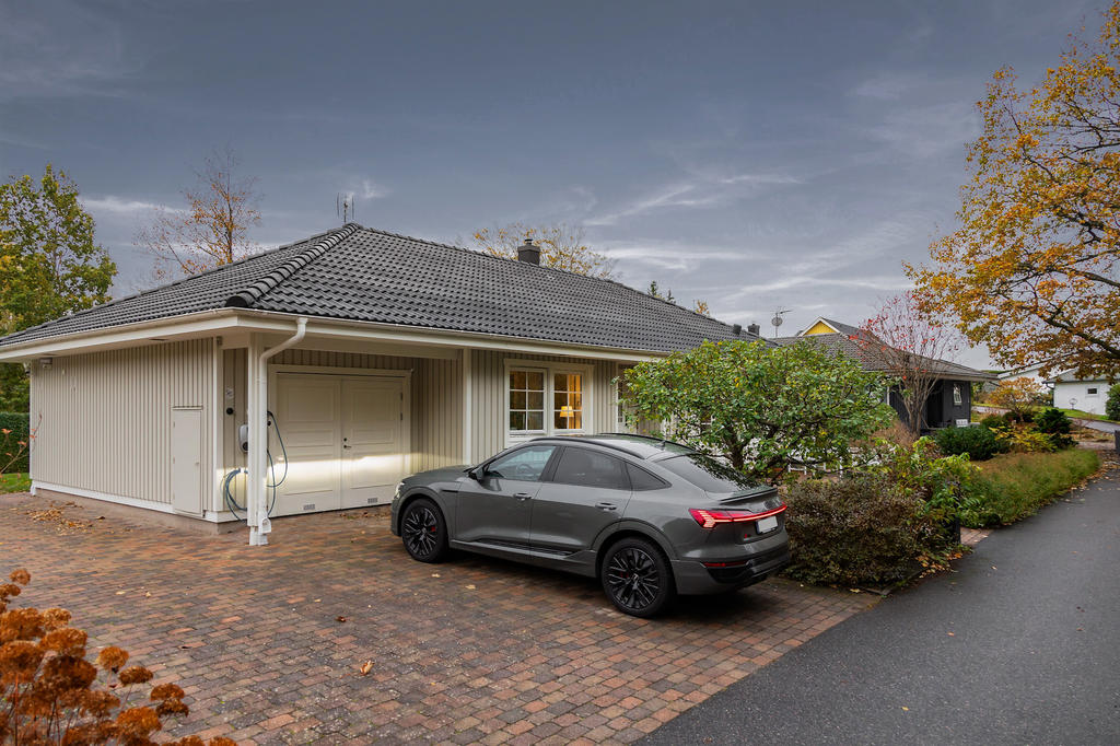 Kvällsbild - Garage/uppfart med dubbel elbilsladdning (22 kWh, Charge Amps Aura) finns vid uppfarten. 