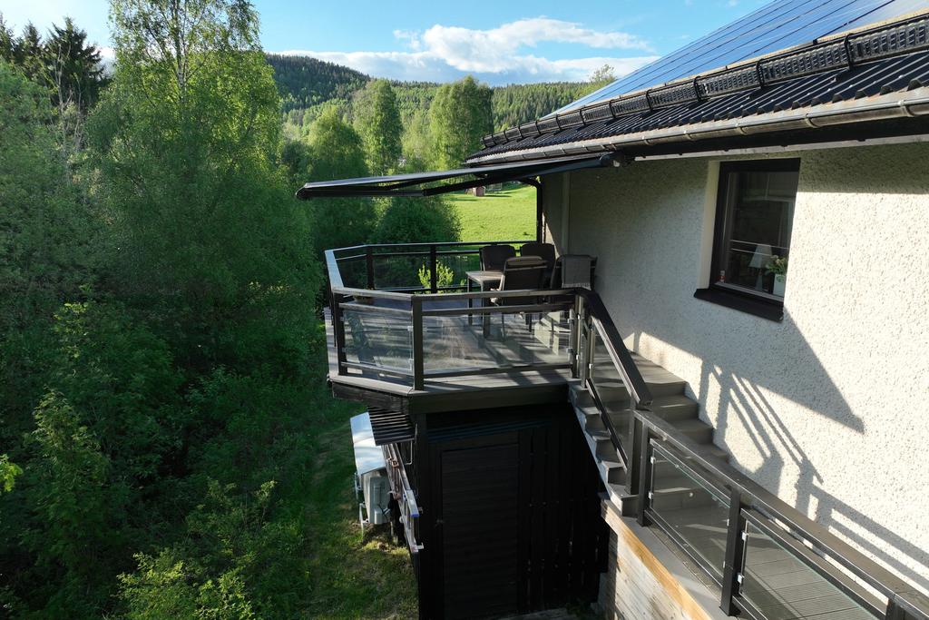 Terrassen ovanpå trädgårdsförrådet med stor markis