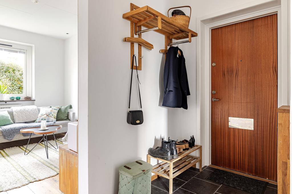 Välkomnande hall med plats för ytterkläder och en praktisk klädkammare intill