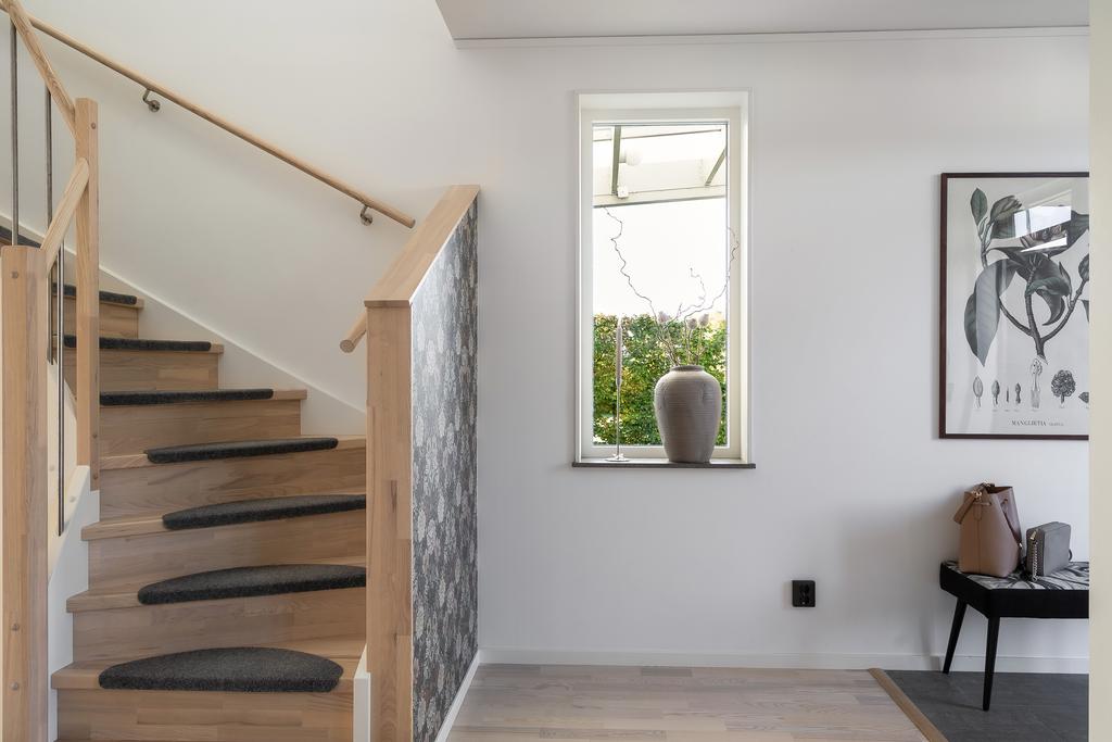 Trappan upp till övre plan går i samma ljusa ton som det genomgående golvet