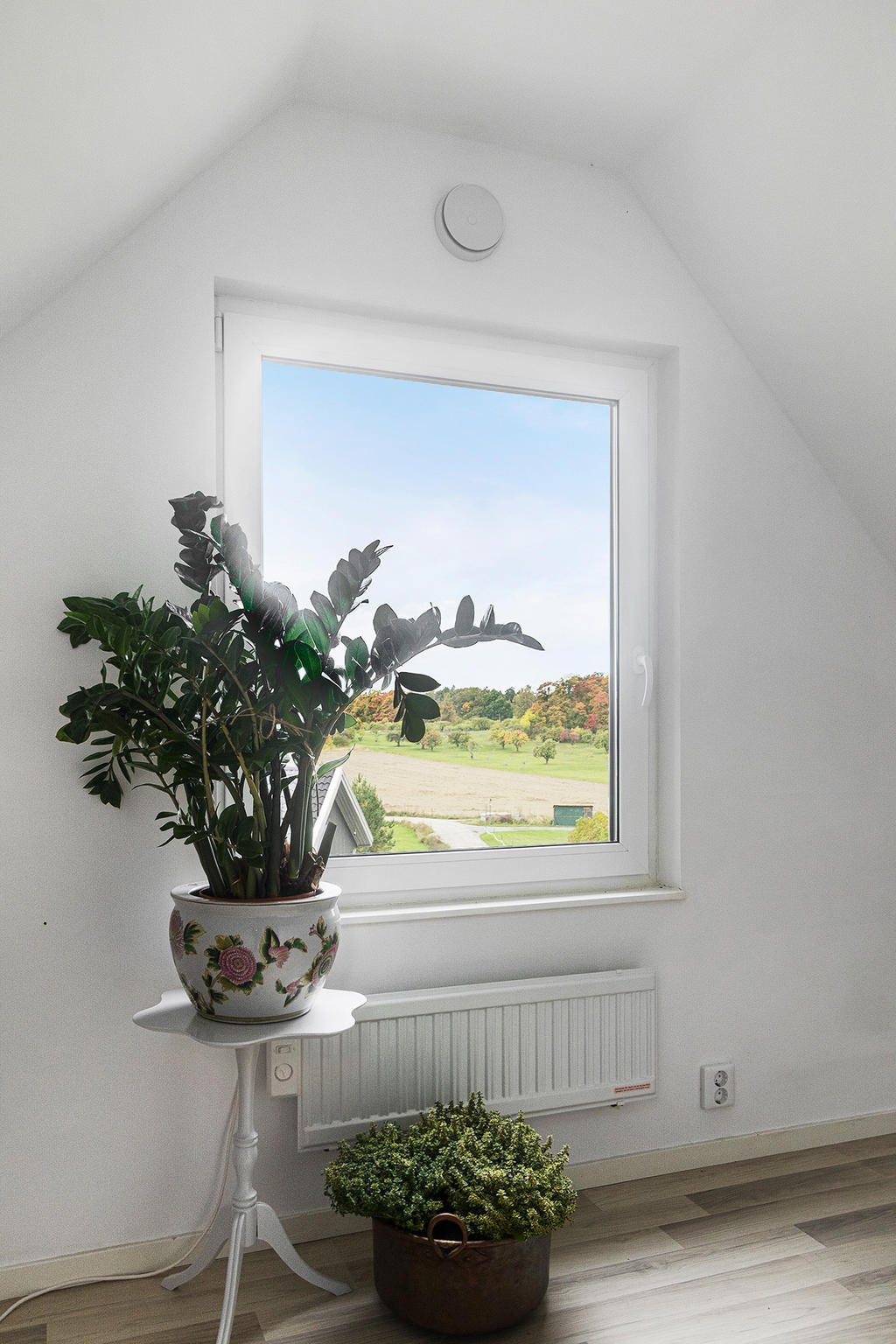 Ett av sovrummet på ovanvåningen ligger med västerläge och erbjuder utsikt över fälten. Tomtens höga läge ger vyer du inte får i ett vanligt villaområde. 