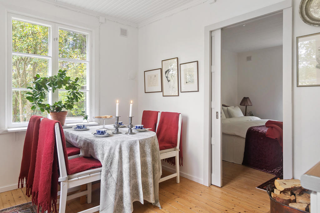 Matplats i ljuset från de stora fönstren, med skjutdörr in till sovrummet på entréplan.