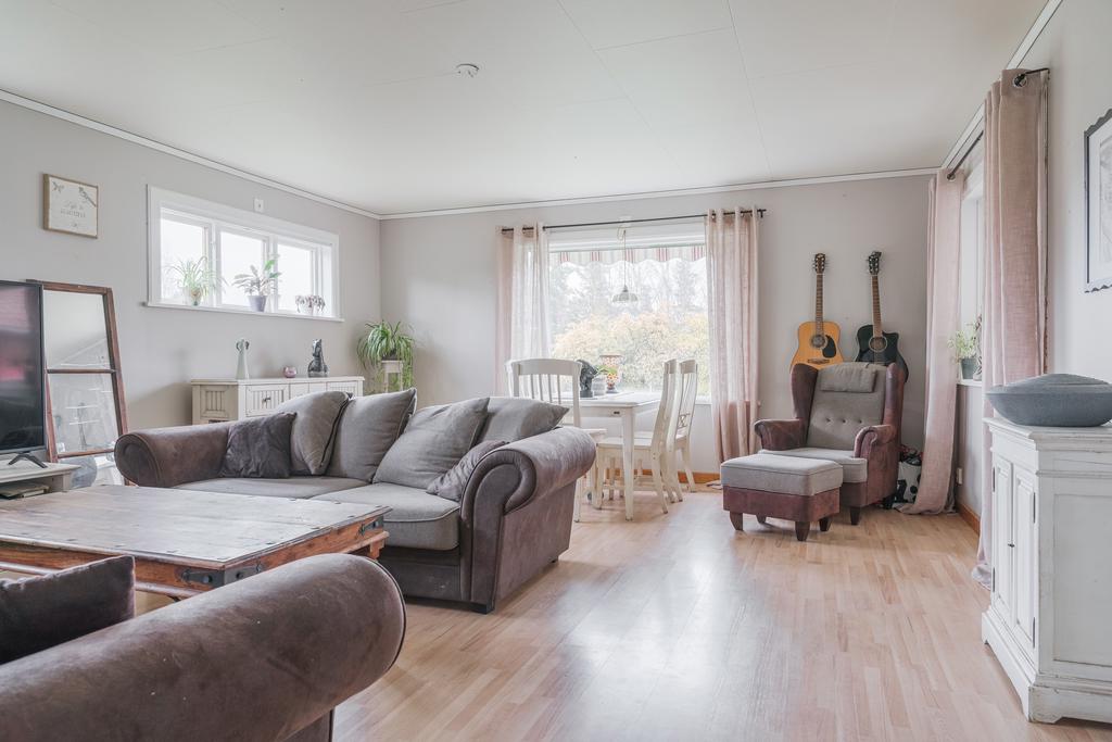 Här finns gott om plats för både soffgrupp och matbord, vilket gör rummet perfekt för sociala sammanhang och familjeliv.