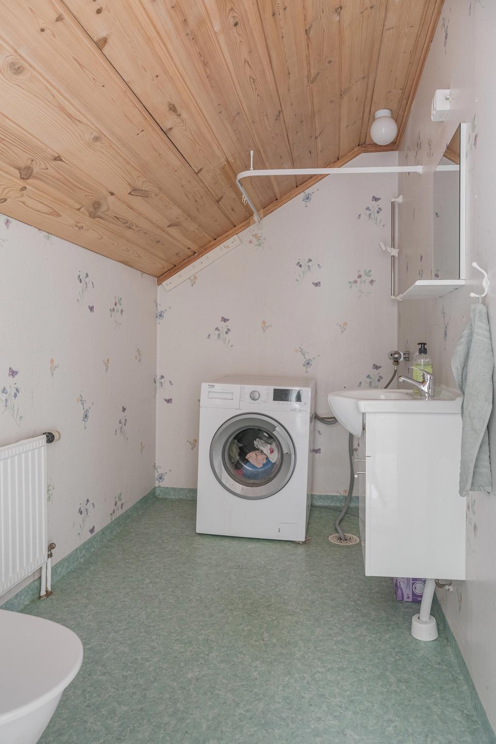 Badrum på övre plan med plats för tvättmaskin, wc och handfat.