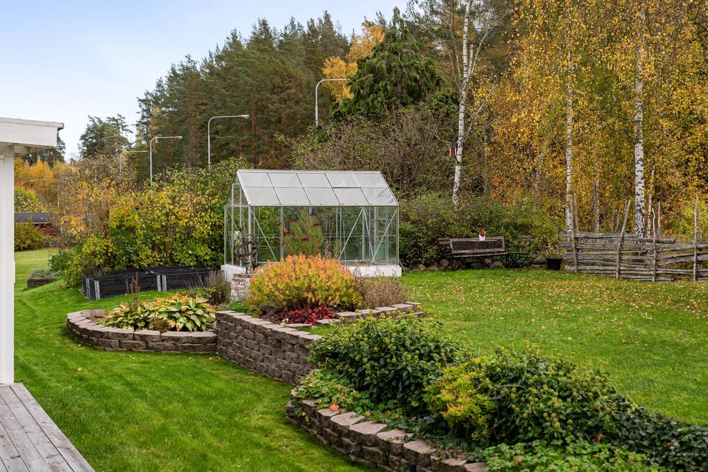 Odlingsdel med pallkragar och växthus