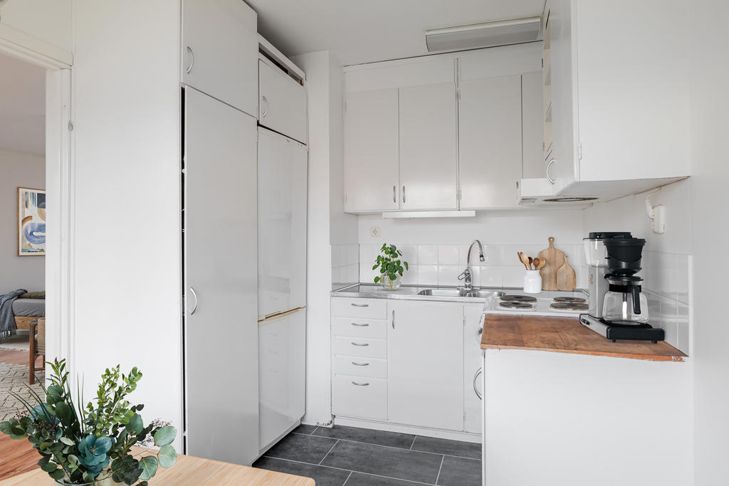 Ljust kök med bra förvaring.
Digitalt stylad. 