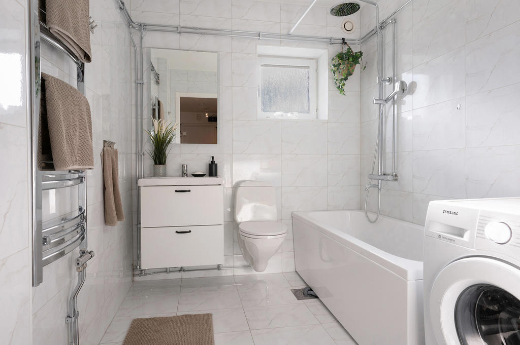 Modernt badrum med tvättmaskin