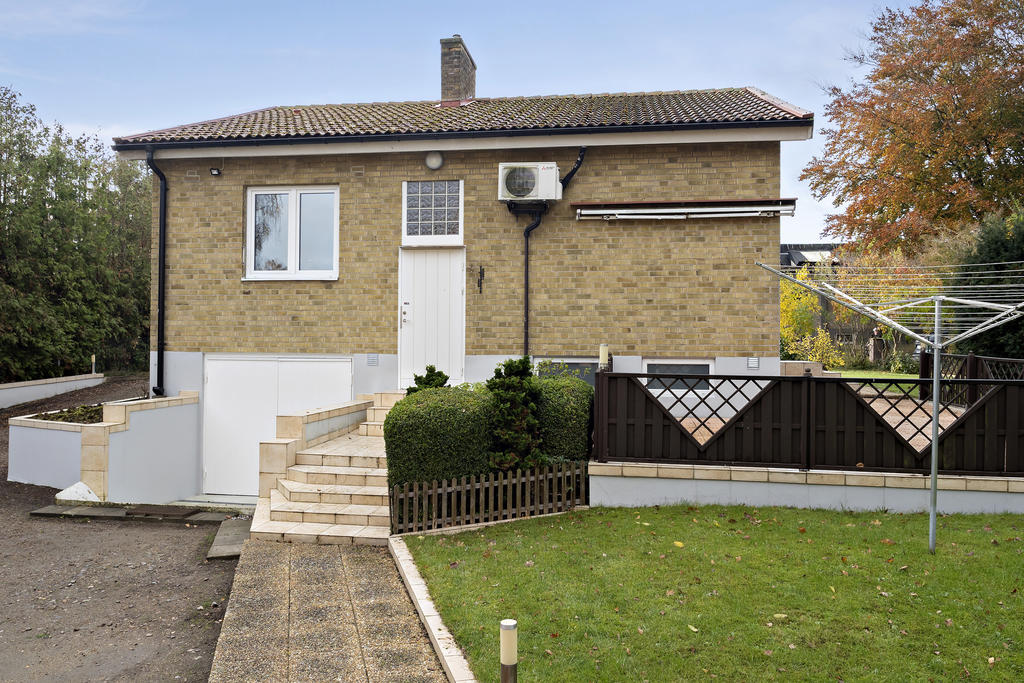 Stenlagd uteplats med markis. Vardagsingången