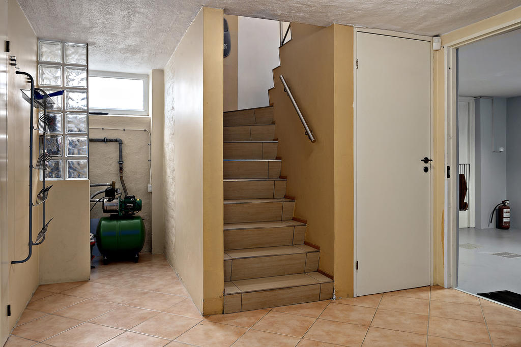 Hall mot garage och förråd under trappan. Vattenfilter.