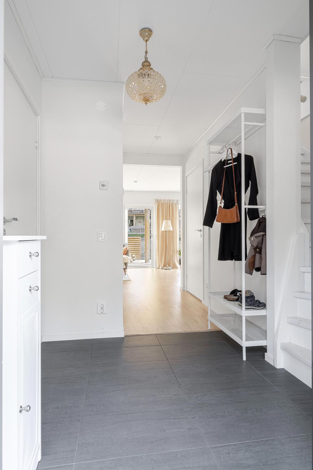 Från entré. Trapp åt höger till övervåningen. Stor klädkammare under trappan. 