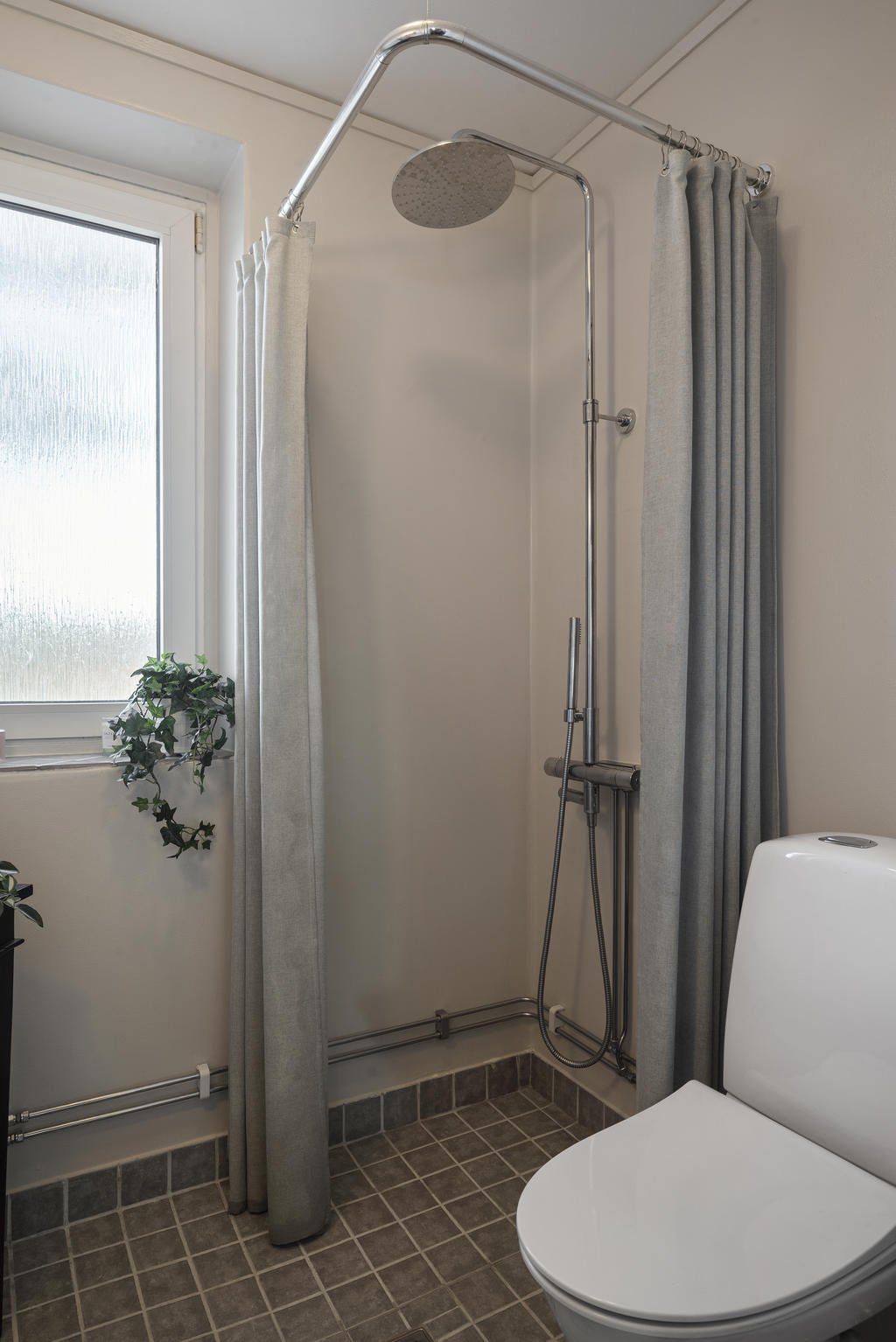 Badrummet har klinker på golvet och våtrumsmålade väggar. Fint ljusinsläpp från fönstret som också kan öppnas för vädring.