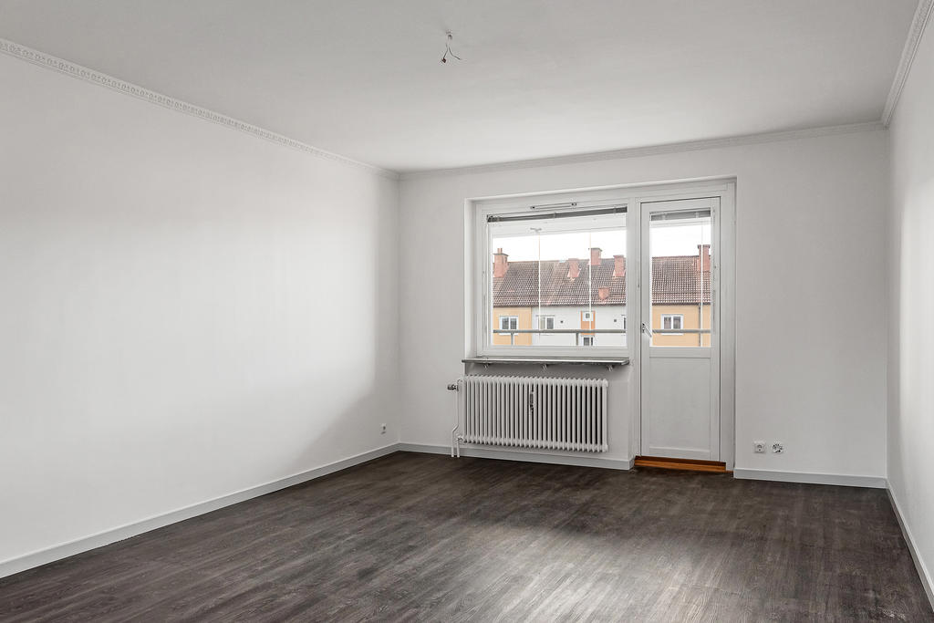 Vardagsrum med gott om yta för soffgrupp och matplats. Utgång till balkong