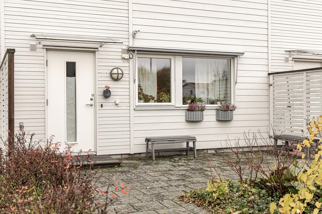 På framsidan finns en välplanerad uteplats som ger ett praktiskt och välkomnande intryck redan vid entrén.