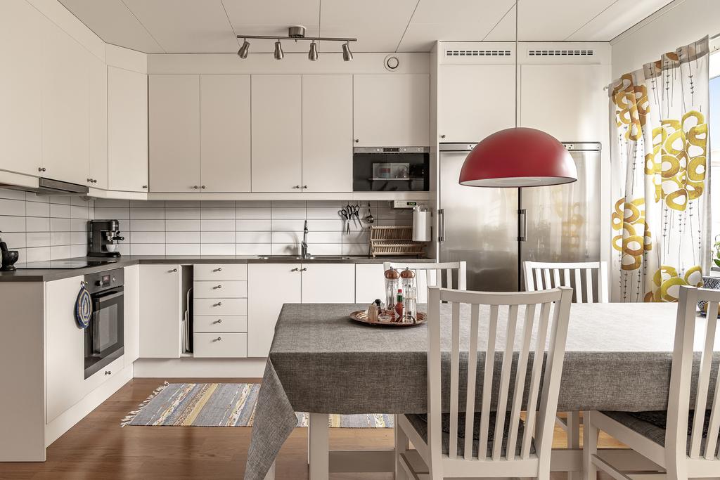 Köket har vita, släta luckor och generösa arbetsytor samt god förvaring.