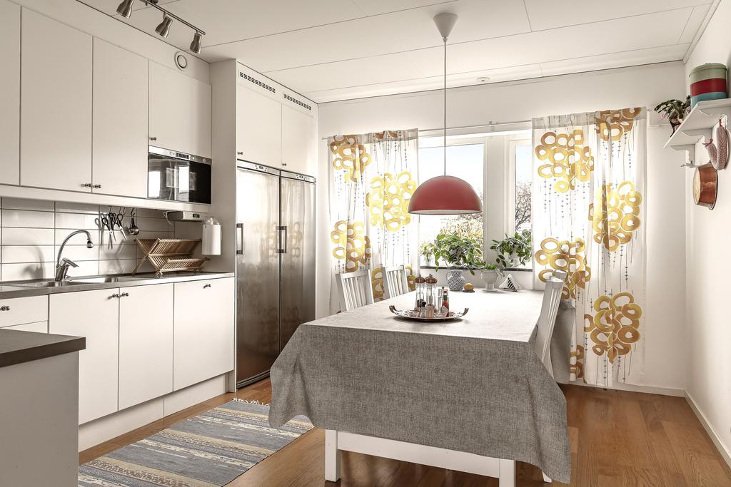 Köket är funktionellt planerat med smart placering av vitvaror och naturligt ljus från stora fönster