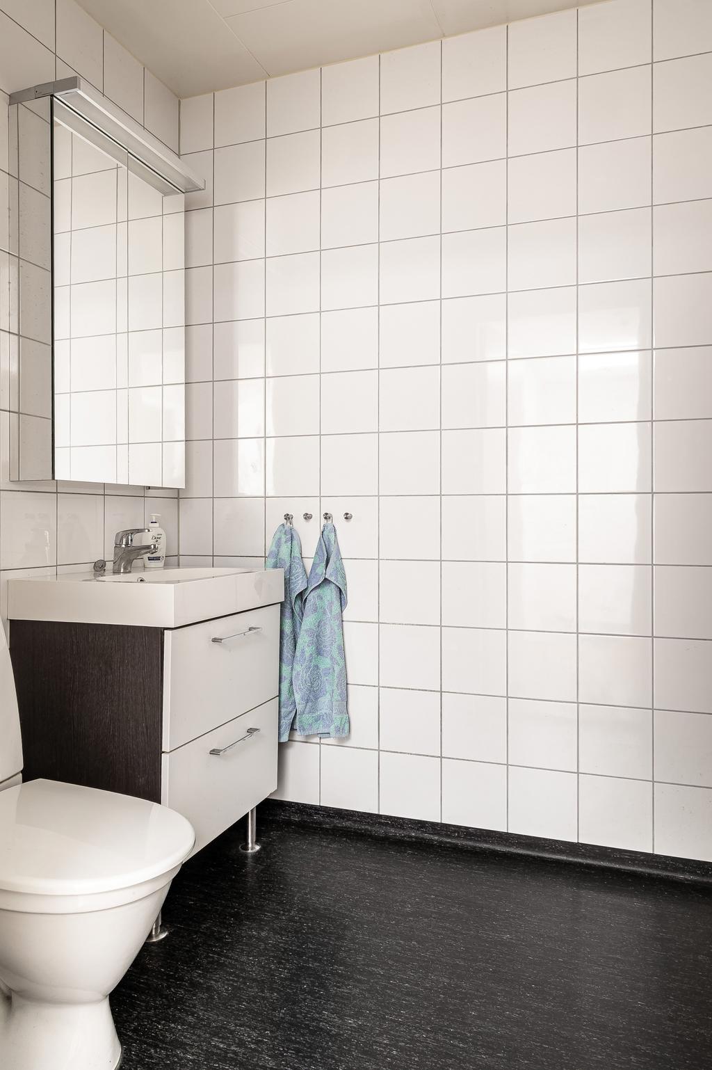 Även det andra badrummet är utrustad med spegelskåp och kommod.