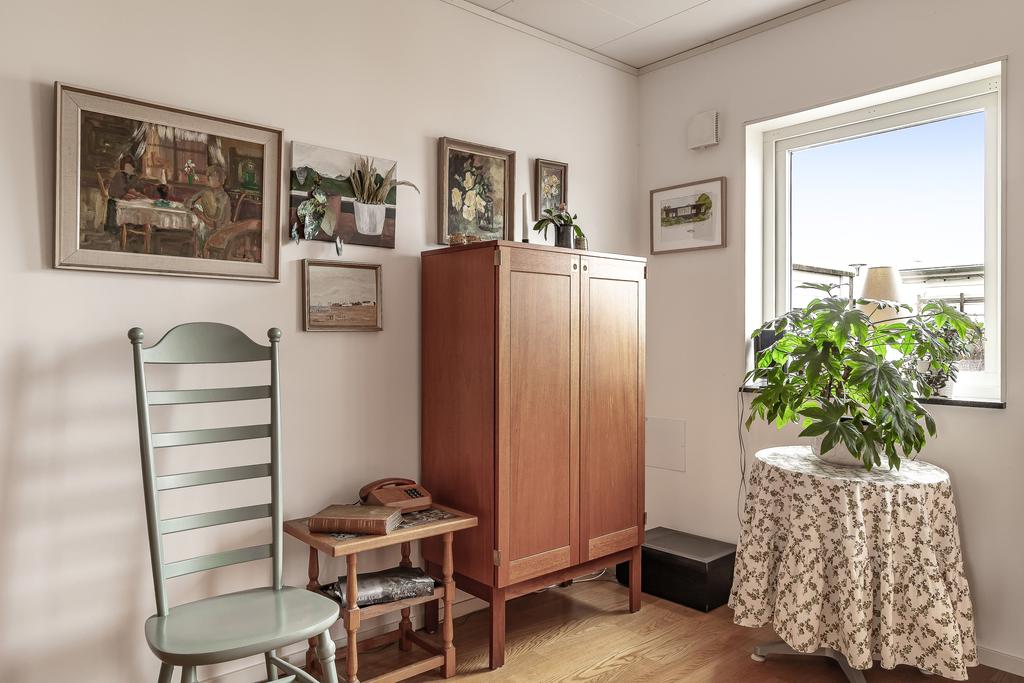 Vardagsrummet har ljusa väggar och parkettgolv som ger ett stilrent och neutralt intryck.