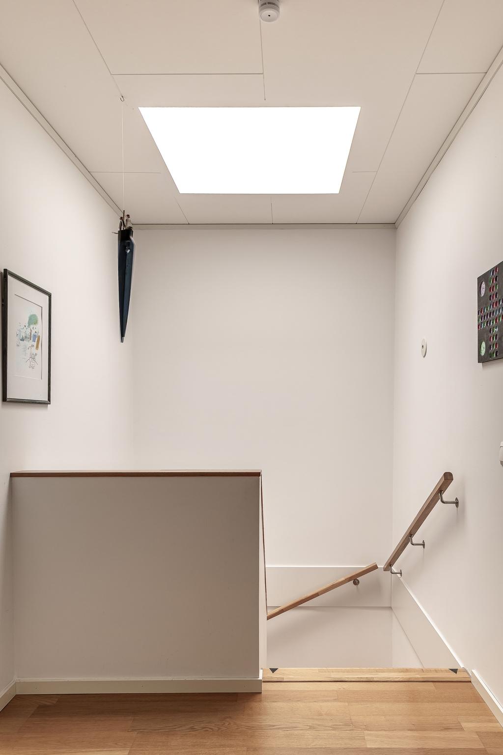 Trappan upp till övervåningen har ett takfönster som släpper in naturligt ljus.