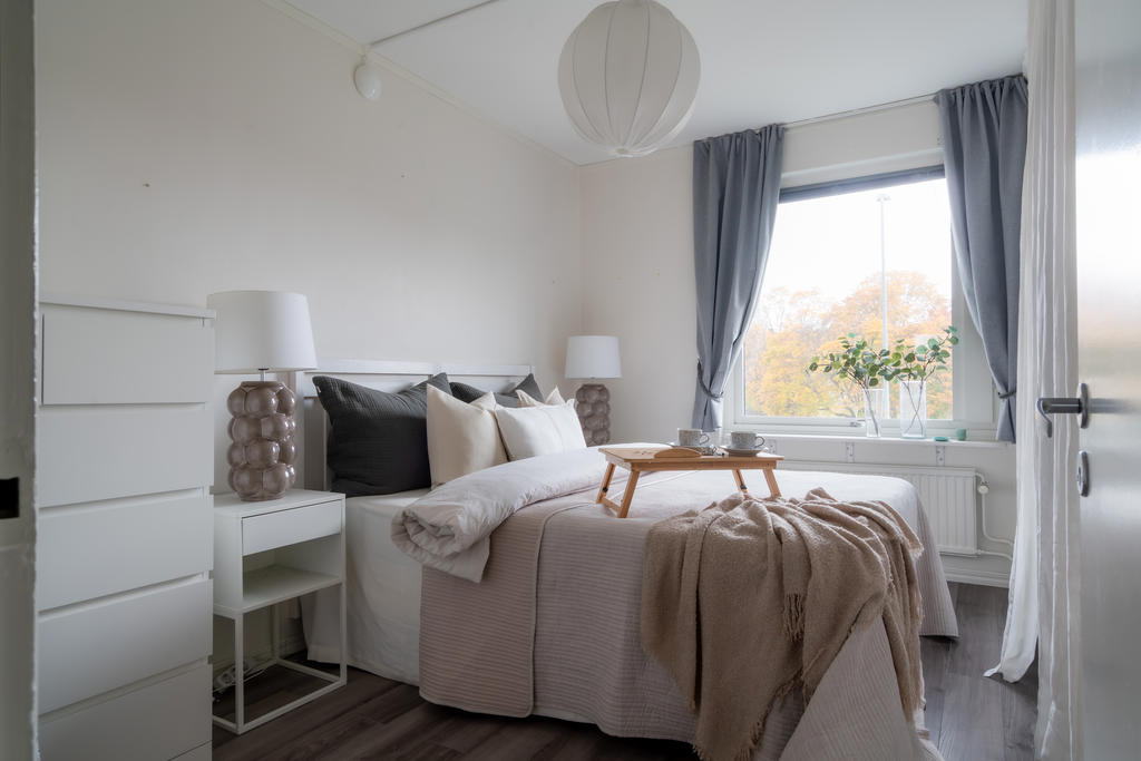 Rymliga sovrummet med plats för både dubbelsäng, sängbord och byrå.